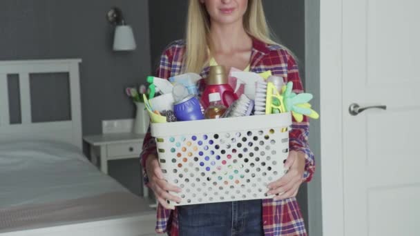 Unrecognizable woman with Basket full of sponges and household chemicals look at camera - Footage, Video