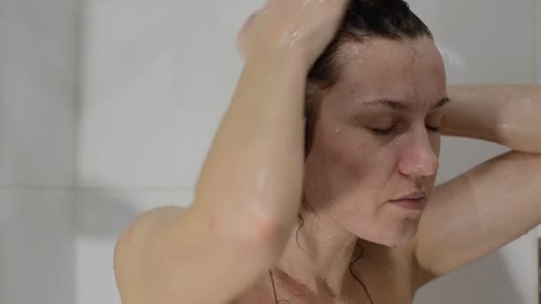 Young charming sexy girl shampoos her head in the bathroom - Felvétel, videó