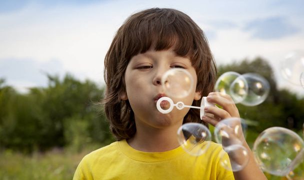 happy boy play in bubbles outdoors - Foto, Imagem