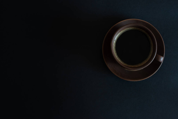 taza de café marrón sobre un fondo negro
 - Foto, imagen