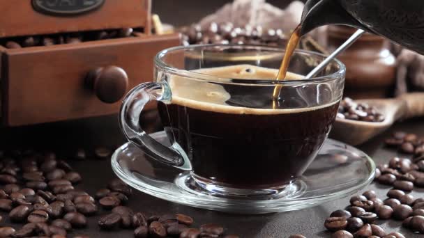 Kaffee mit Dampf aus einer Kaffeekanne in eine Tasse gegossen - Filmmaterial, Video
