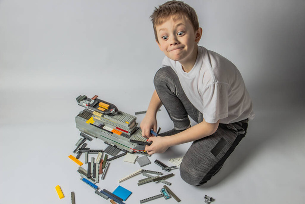 The boy collects a constructor from colorful parts - Фото, изображение