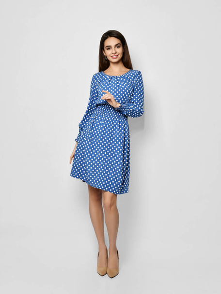 Young beautiful woman posing in new casual fashion spring blue polka dot dress full body - Foto, afbeelding