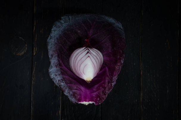 Blue onion in a leaf of cauliflower. The texture of vegetables. Top. - Valokuva, kuva