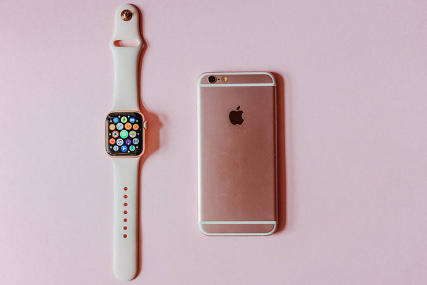 Růžové hodinky Apple a růžové iphone leží na pozadí. - Fotografie, Obrázek