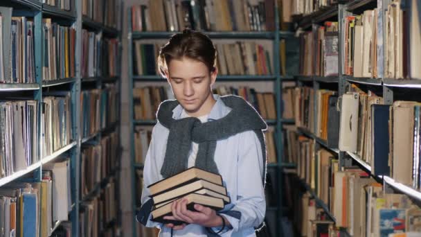 Portret chłopca z książkami w bibliotece - Materiał filmowy, wideo