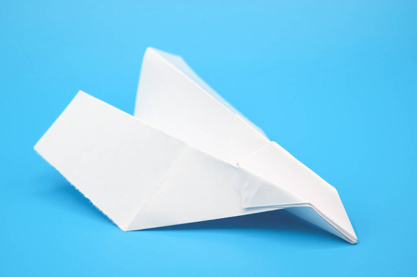 White paper plane on blue background. - Фото, изображение
