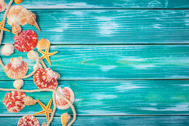 Different sea shells on color wooden background - Fotografie, Obrázek