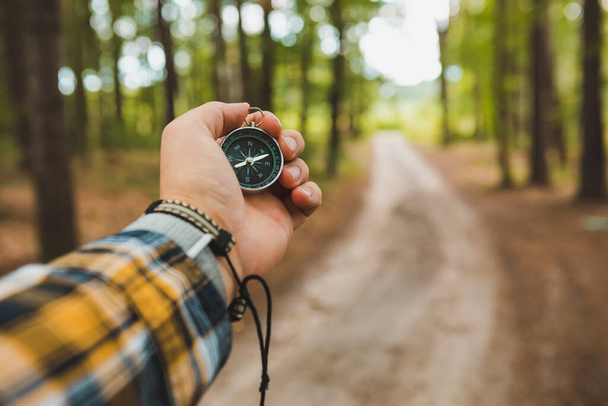 compass in man hand hiking by forest trail travel concept - Photo, image