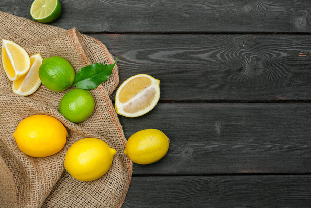 lemons and limes on a wooden background. Creative photo. - Zdjęcie, obraz