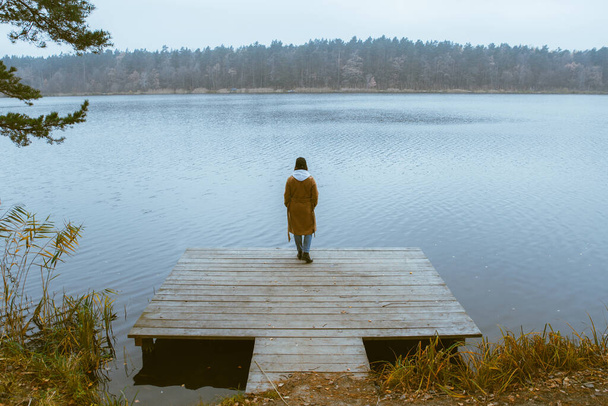 jesień jezioro sezon kobieta w płaszcz na drewnianym molo upadku - Zdjęcie, obraz