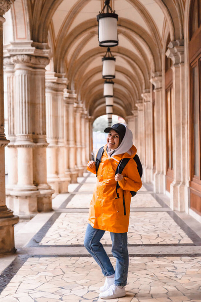 женщина турист ходьба с рюкзаком в желтом дождевик городской туризм скопировать пространство
 - Фото, изображение