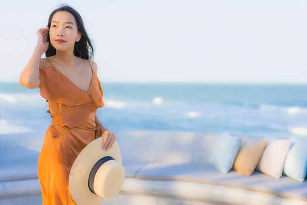 Portret piękna młoda azjatycka kobieta szczęśliwy uśmiech wokół morza ocean plaży i błękitne niebo dla wypoczynku podróży wakacje - Zdjęcie, obraz