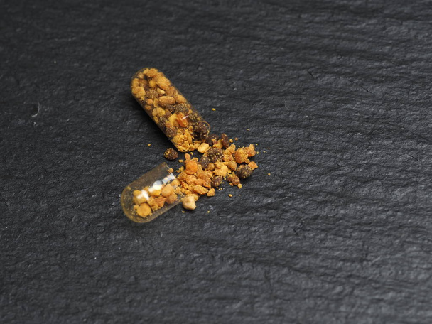 Σπόροι γύρης μέλισσας σε διαυγή καψάκια για καθημερινή χρήση. Υγιές φυσικό φάρμακο για τη γρίπη. - Φωτογραφία, εικόνα