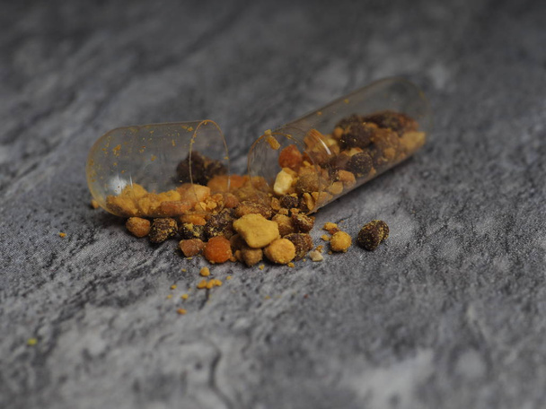 Σπόροι γύρης μέλισσας σε διαυγή καψάκια για καθημερινή χρήση. Υγιές φυσικό φάρμακο για τη γρίπη. - Φωτογραφία, εικόνα