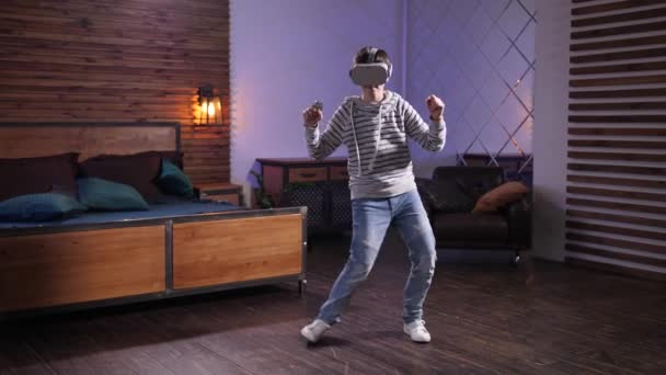 Joyful teen in VR goggles performing funny dance - Filmati, video