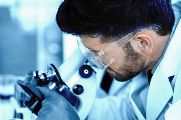 verschwommener wissenschaftlicher Hintergrund eines Forschers unter dem Mikroskop im Labor - Foto, Bild