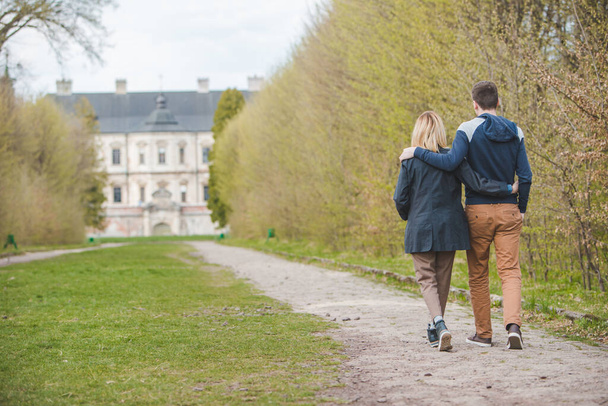 pareja caminando por el callejón frente al viejo castillo de belleza. lugar romántico
 - Foto, imagen
