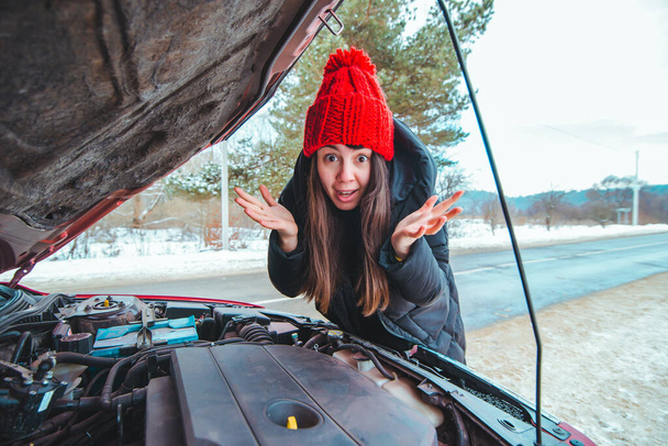 donna guardando motore auto strada assistenza concetto stagione invernale - Foto, immagini