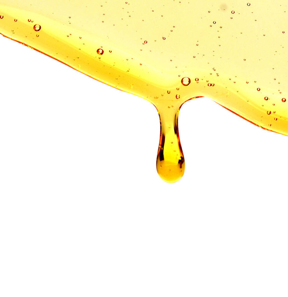Honey flowing on a white background  - Foto, afbeelding