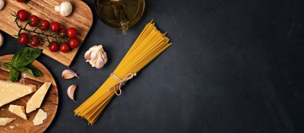 Puesta plana de ingredientes para cocinar pasta italiana. Espaguetis, tomates, aceite, ajo, parmezano. Vista superior del concepto tradicional italiano cusine
 - Foto, Imagen