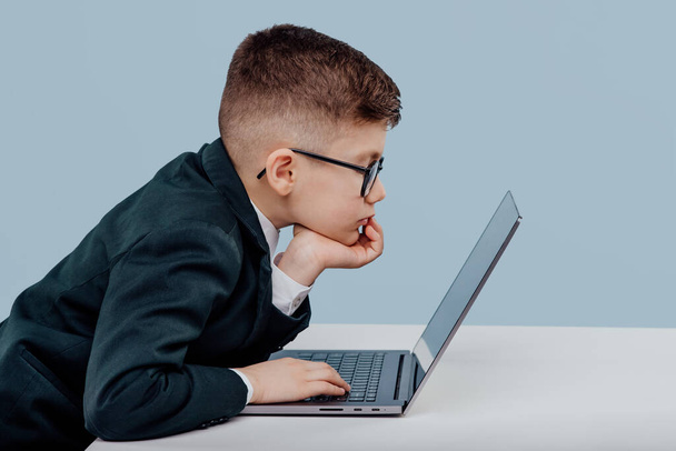 side view schoolboy. with glasses using a laptop - Photo, image
