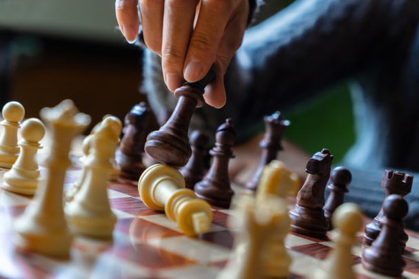 Рука предпринимательницы, играющей в шахматы для успеха в соревнованиях
 - Фото, изображение