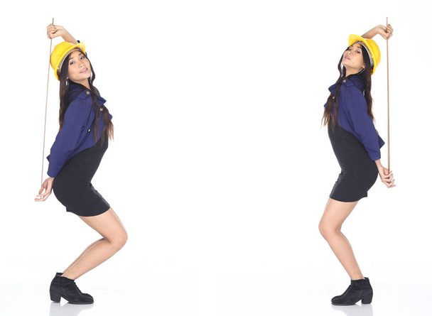 Дві азіатські інженери-архітектори жінка в жовтому капелюсі, безпечний джинсовий піджак коротке спідничне обладнання і довгий правитель, студія освітлює білий фон ізольований простір копіювання - Фото, зображення