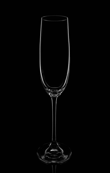 Copo de champanhe vazio sobre um fundo preto, elegantemente iluminado nas laterais. Conceito, misteriosa vida de clube
. - Foto, Imagem