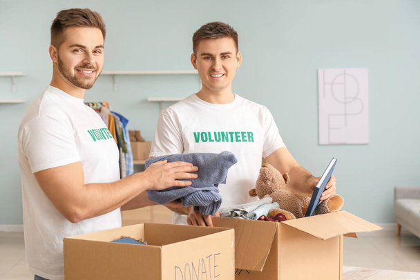 Wolontariusze z darowiznami dla biednych ludzi w pomieszczeniach - Zdjęcie, obraz
