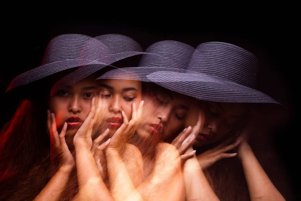 Stroboscopic imagen de un modelo en muchas chicas, Asia Tan Skin mujer pelo rizado desgaste oscuro sombrero vestido rojo, estudio de retrato iluminación fondos negros, foto de movimiento borroso
 - Foto, Imagen