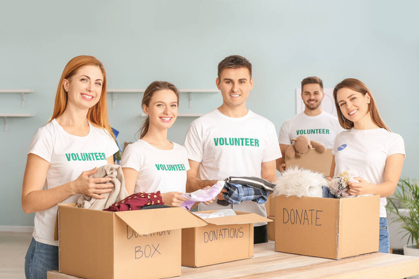 Ομάδα εθελοντών με δωρεές για φτωχούς ανθρώπους σε εσωτερικούς χώρους - Φωτογραφία, εικόνα