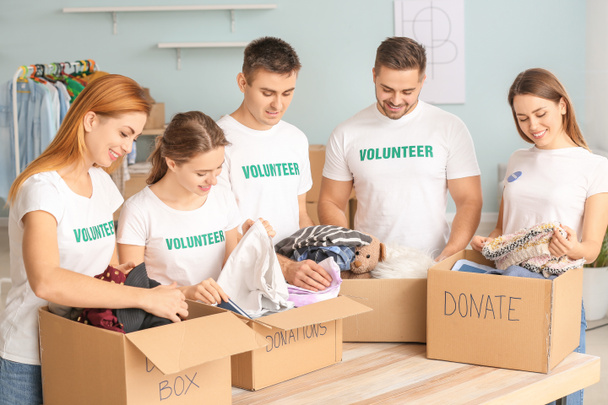 Team of volunteers with donations for poor people indoors - Fotoğraf, Görsel