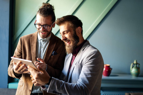 Muotokuva onnellinen nuoret liikemiehet käyttävät digitaalisia laitteita kokouksessa - Valokuva, kuva