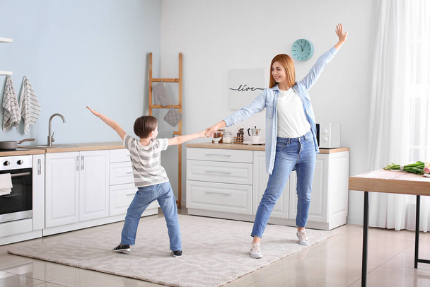 Feliz madre y su pequeño hijo bailando en la cocina
 - Foto, imagen