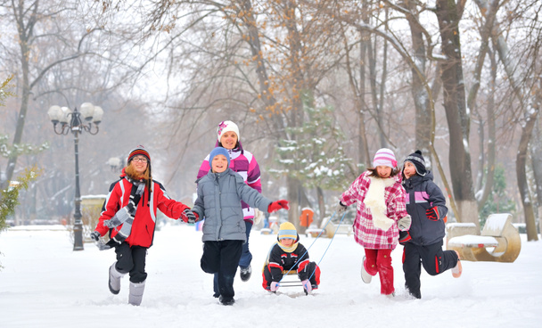 Grupa dzieci i matka gry na śniegu w okresie zimowym - Zdjęcie, obraz