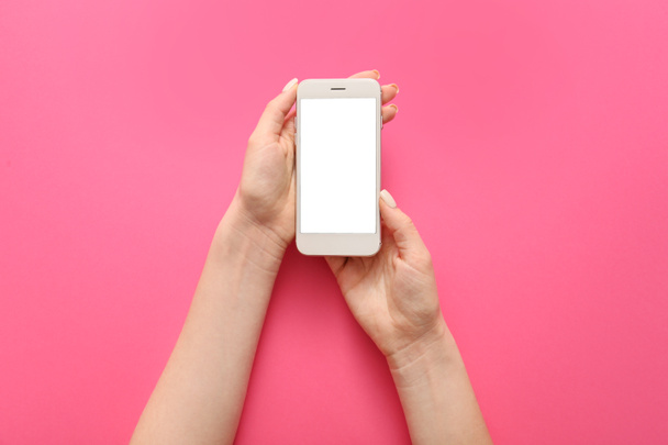 Female hands with mobile phone on color background - Photo, Image