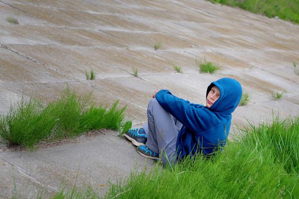 nastolatek siedzi na betonowej płycie kopca 2020 - Zdjęcie, obraz