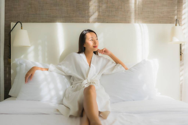 Portret piękna młoda azjatycka kobieta relaks uśmiech na łóżku w sypialni wnętrza - Zdjęcie, obraz