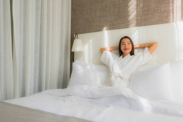 portrait belle jeune asiatique femme relax sourire sur lit dans chambre intérieur - Photo, image