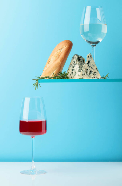 Blue cheese with bread, wine and rosemary on a blue background. Copy space for your text. - Photo, Image