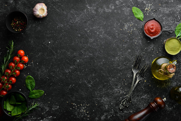 Black cooking background. Vegetables and spices on the table. Top view. Free space for your text. - Foto, Imagem