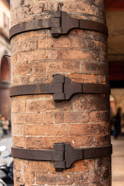 Close-up van een oude stenen zuil versterkt met smeedijzeren riemen, gevaar voor instorting, Bologna centrum, Emilia-Romagna, Italië, Europa - Foto, afbeelding