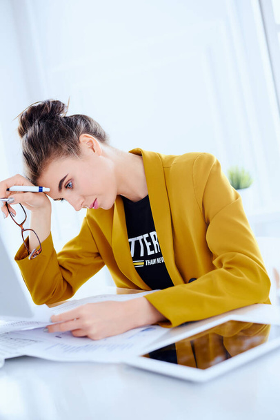 Tired  business woman with desktop and documents at her office - Фото, изображение