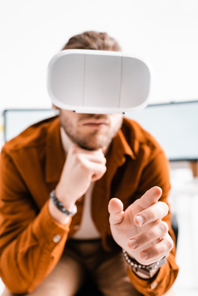 Selective focus of 3d artist in vr headset gesturing on white background - 写真・画像