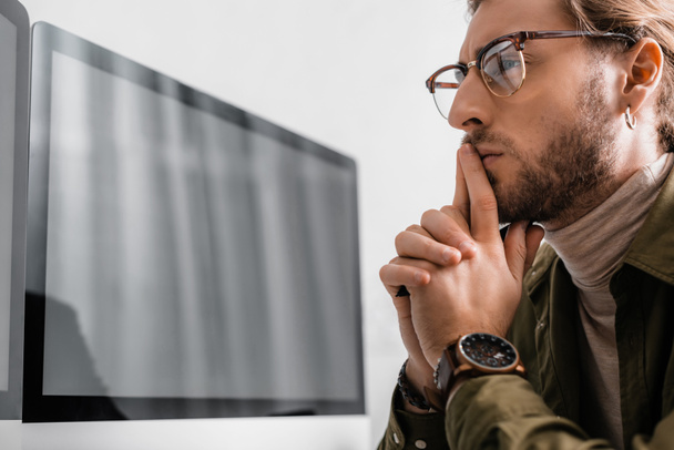 Thoughtful 3d artist looking at computer monitor isolated on grey  - Foto, Imagem