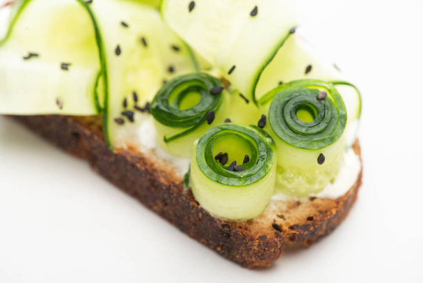 close up view of fresh cucumber toast with seeds on white background - Foto, immagini