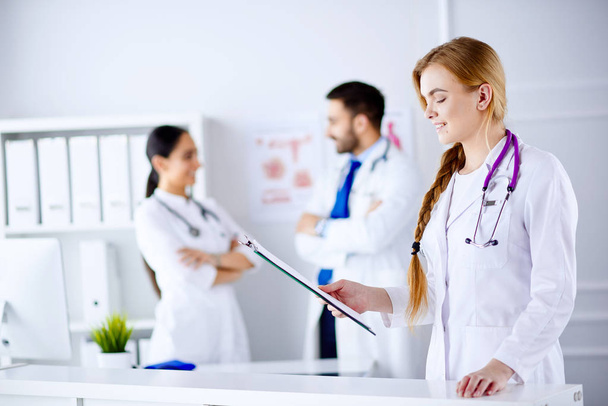 Žena Doktor stojící a čtení diagnózy před svým týmem v nemocnici - Fotografie, Obrázek