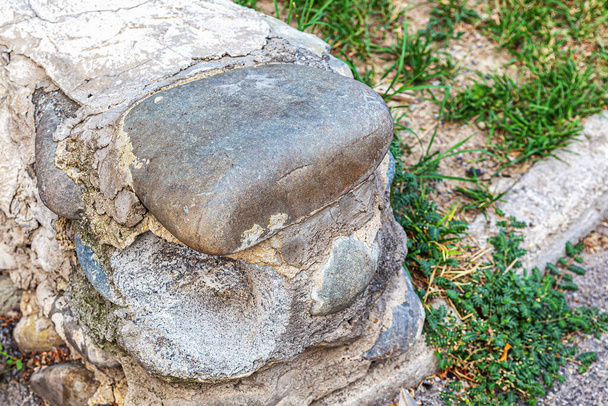 Pflastersteine in einem niedrigen Steinzaun, der mit Zementmörtel zusammengehalten wird - Foto, Bild