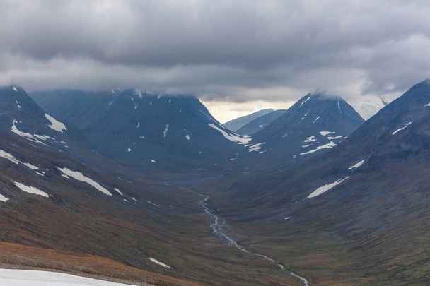 Widok na dolinę. Północna Szwecja, Park Narodowy Sarek w burzliwą pogodę jesienią. ukierunkowanie selektywne - Zdjęcie, obraz